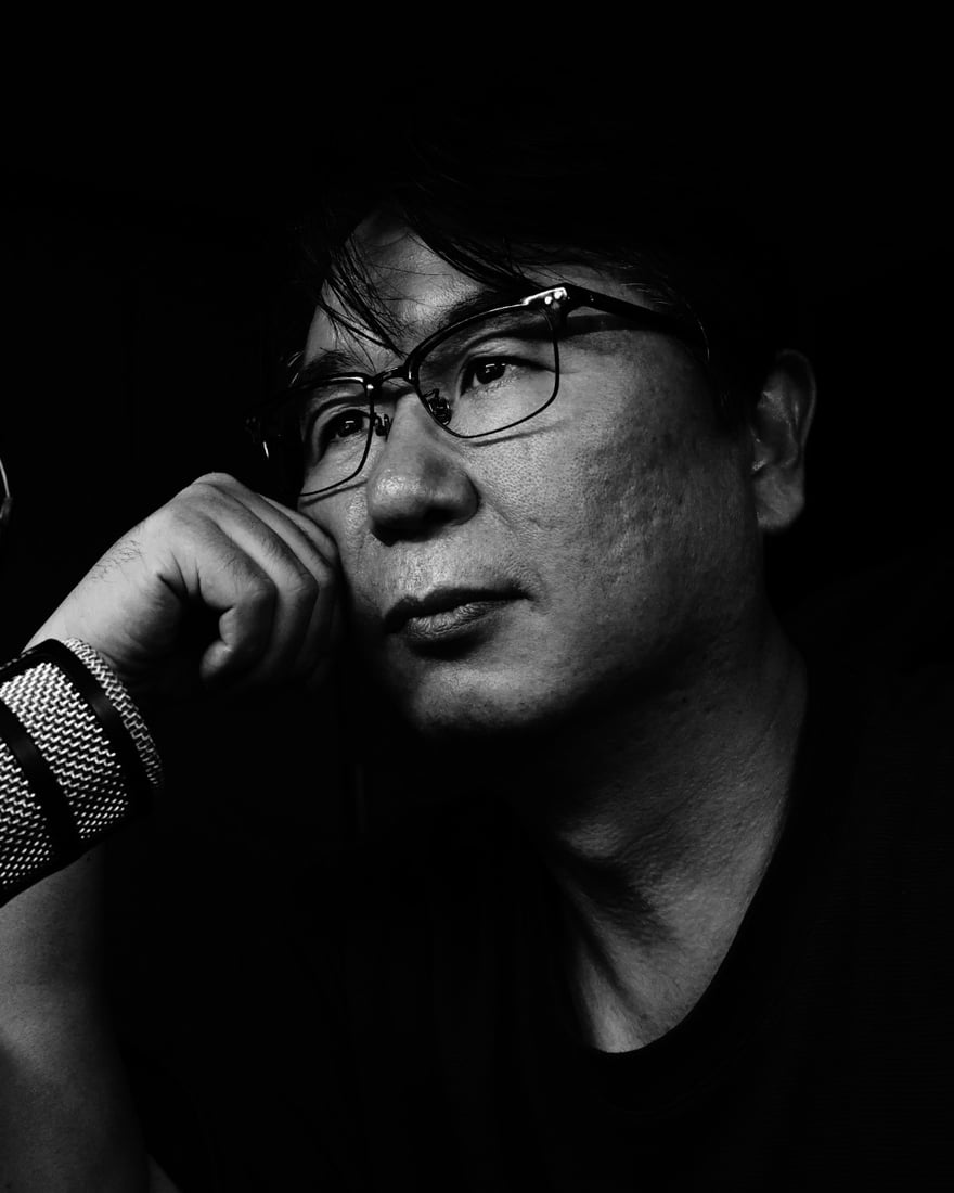 마이크 앞에서 턱을 괴고 생각에 잠긴 이선종 교수 흑백 사진